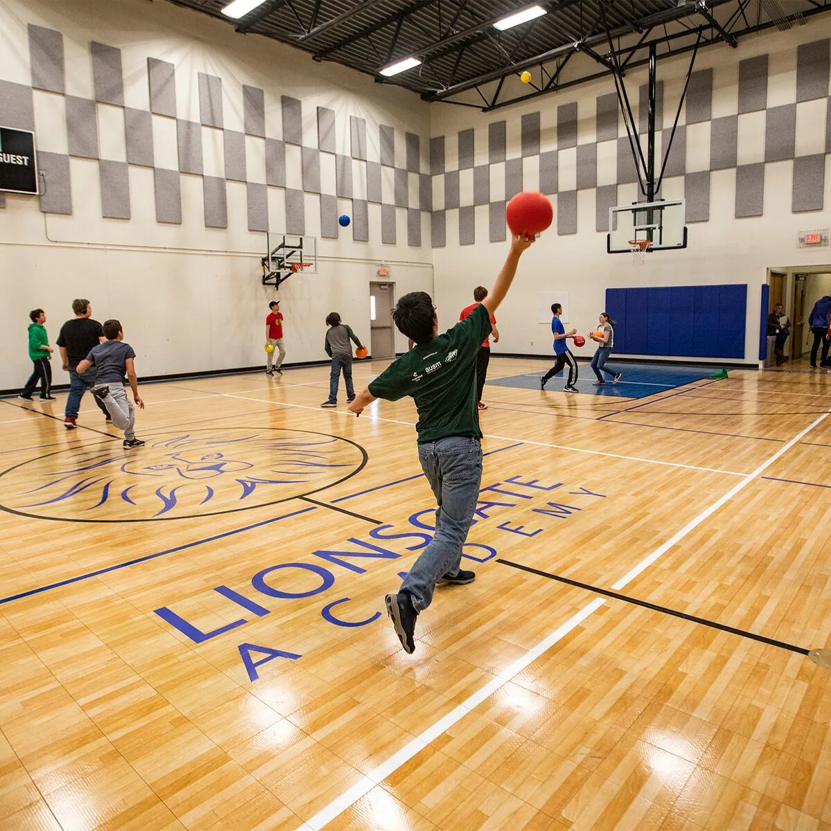 Kids playing basketball on an indoor court at Lionsgate Academy