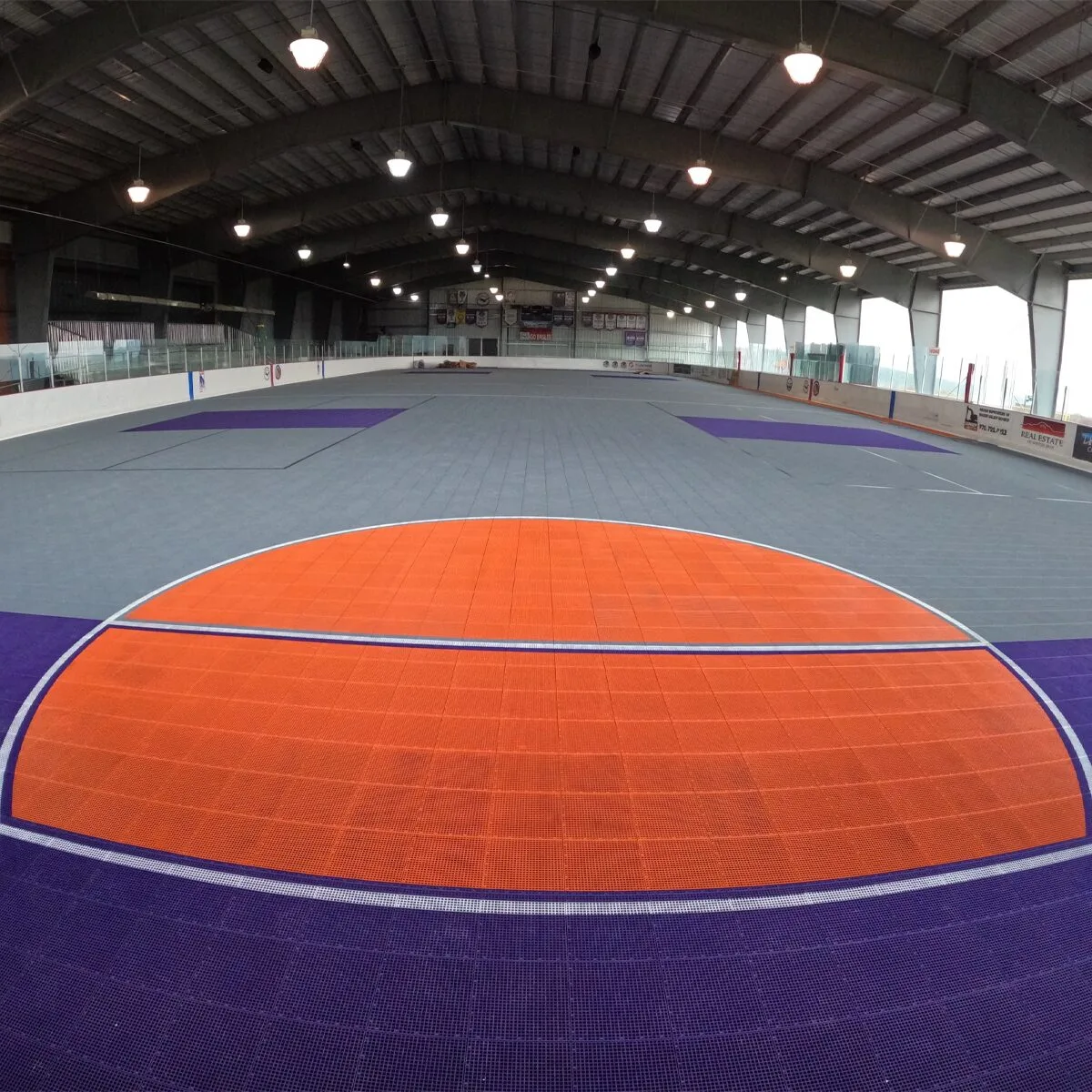 Wide view of a PowerGame court featuring orange and purple court flooring