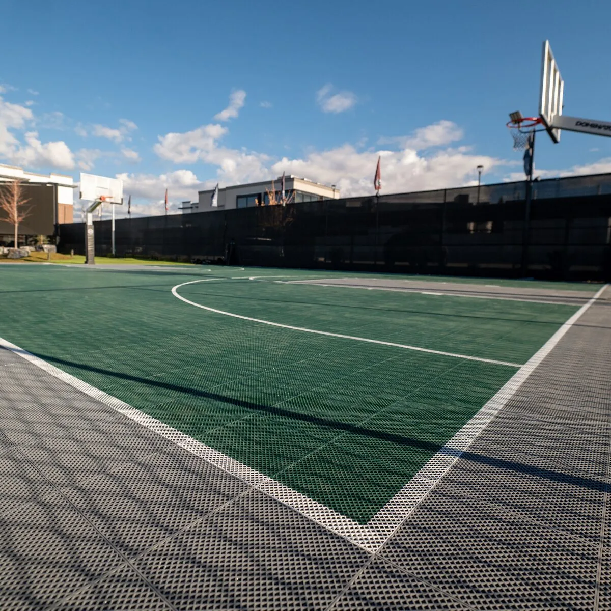 Outdoor basketball court at a facility on a sunny day