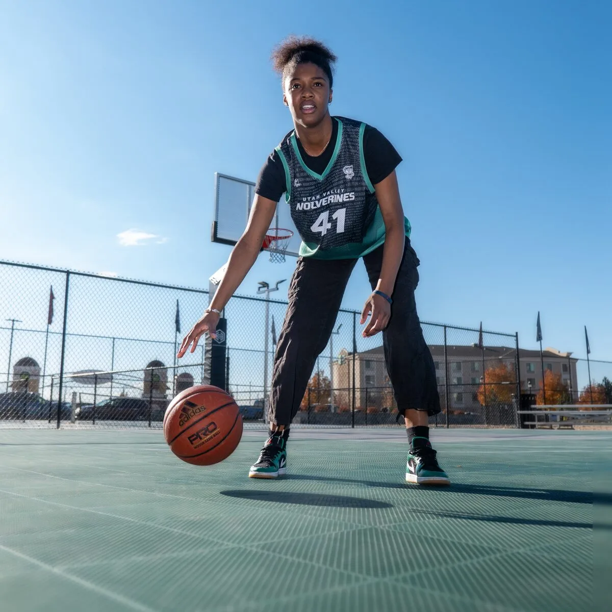 Female basketball player dribbling a basketball on an outdoor court