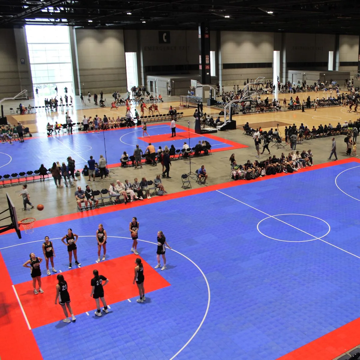 A group of players circling around a basketball hoop during a basketball event