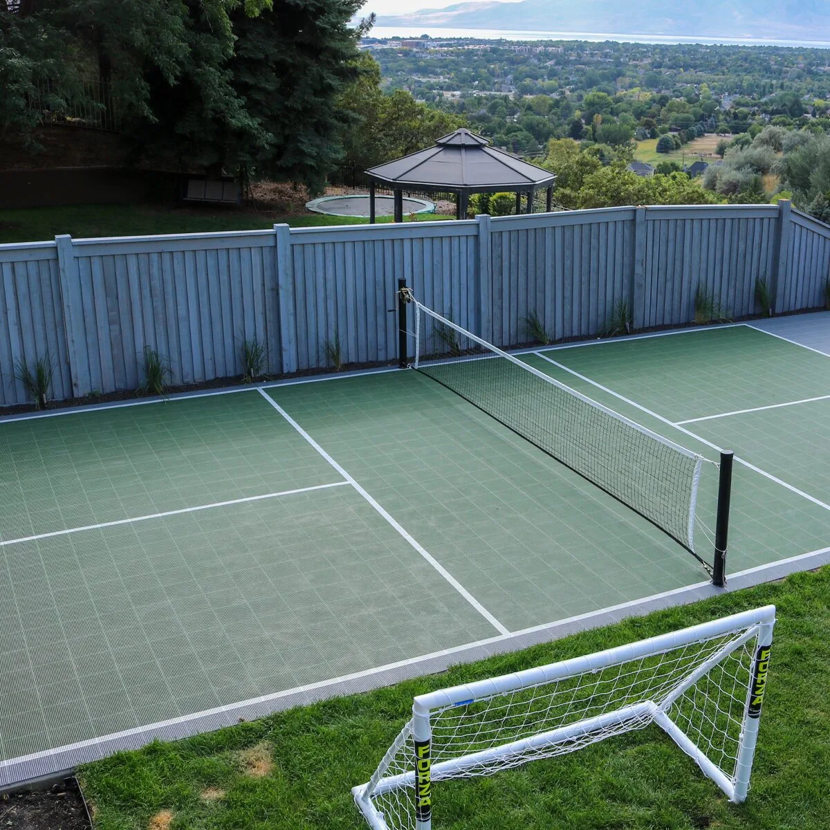 An outdoor racket sport surface surrounded by trees