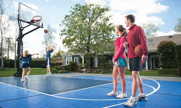 A family enjoying their residential outdoor basketball court